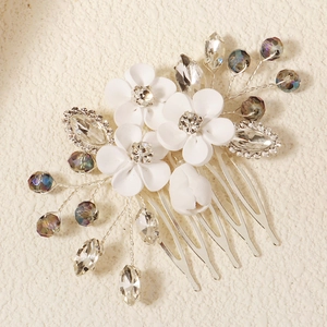 Detailed close-up of handmade white clay flower hair comb with rhinestones and beads