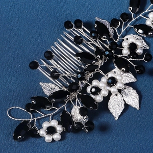 Détail d'un peigne à cheveux de mariée avec pierres noires, perles et feuilles argentées