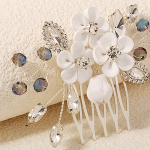 Macro detail of bridal hair comb with matte white flowers and sparkling crystals