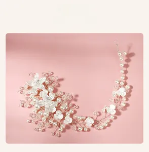Détail de vigne de cheveux de mariée avec fil d'argent, perles blanches et fleurs en cristal