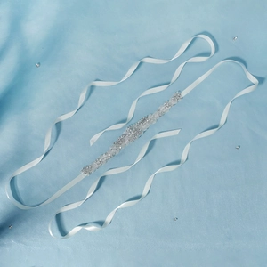 Close-up of sparkling bridal belt with rhinestones and white silk ribbon detail