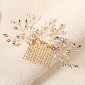 Détail d'un peigne à cheveux de mariée doré avec perles faites main et strass brillants