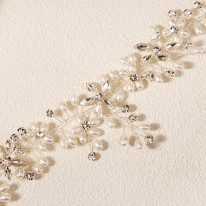 Detailed view of handmade bridal hair comb with white pearls and sparkling rhinestones