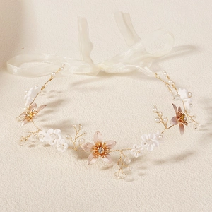 Détail d'un bandeau de mariée fait main avec fleurs en tissu blanc et cristaux