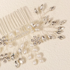 Gros plan d'un peigne à cheveux de mariée avec perles blanches et strass brillants