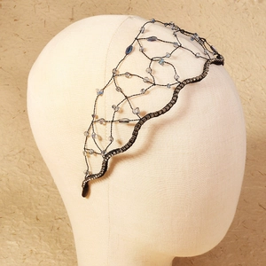 Close-up of luxury dark mesh bridal headband with sparkling blue crystals and black rhinestones