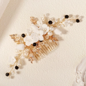 Détail d'un peigne à cheveux fleuri en céramique avec fils dorés et perles