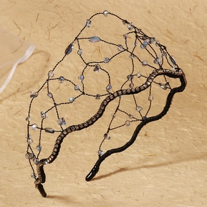 Close-up of handmade bridal headband with mesh texture and iridescent crystal beads