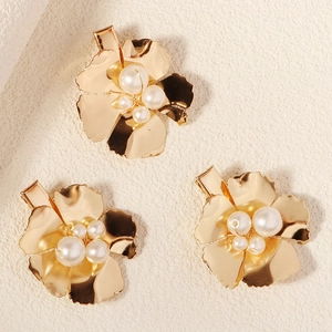 Vue détaillée de trois barrettes à fleurs dorées avec des ornements de perles élégantes