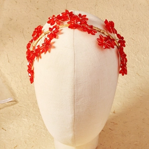 Close-up of handmade red crystal flower bridal headband with golden wire weaving details