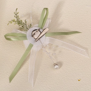 Detail of the back view showing the metal clip and pin of the white flower brooch