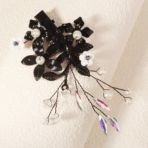 Détail macro de la pince à cheveux fleur noire avec perles et glands en cristal