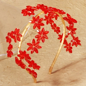Close-up of handmade bridal headband featuring red crystal flowers and gold wire detail
