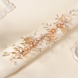 Vue détaillée d'un peigne à cheveux de mariée fait main avec fleurs d'or et perles