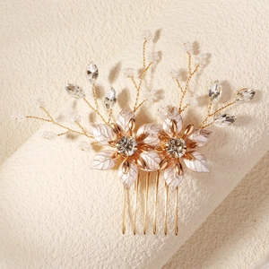 Elegant gold bridal hair comb featuring white enamel flowers and sparkling rhinestones