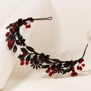 Detail of dark retro Gothic headband featuring black metallic leaves and red crystal beads