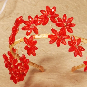 Detailed macro of handmade red crystal flower headband with gold wire wrapping