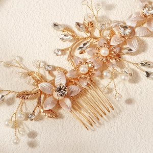 Vue macro d'un peigne de mariée avec fleurs dorées, strass et perles blanches