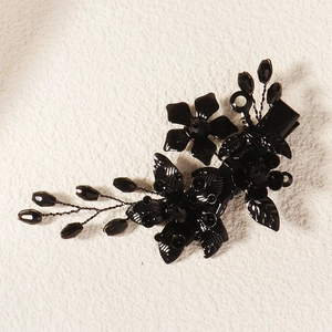 Détail macro d'une pince à cheveux fleur en métal noir gothique avec perles Halloween