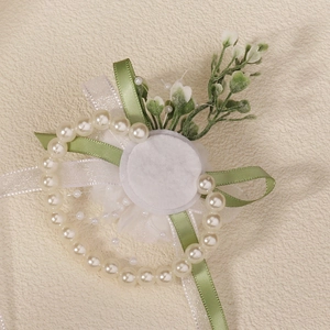 White flower wrist corsage with pearls and green ribbons for wedding bridesmaid dress