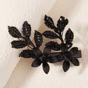 Détail d'une pince à cheveux fleurie en métal noir avec nervures de feuilles pour Halloween