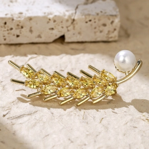 Detail of wheat ear brooch with yellow marquise zircons and a white pearl on gold base