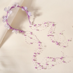 Vue détaillée du bandeau floral violet avec de longs glands de perles et des perles