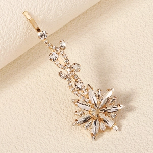 Detailed macro shot of a golden bridal hair pin with sparkling crystal rhinestones