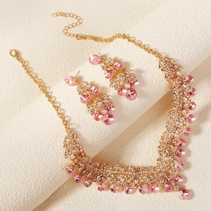 Detailansicht eines luxuriösen goldenen Brautschmucksets mit rosa Kristallsteinen