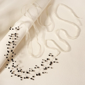 Macro detail of handmade bridal headband with black faceted crystals and thin silver wire