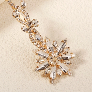 Elegant gold hair clip featuring a sparkling rhinestone starburst and vine design for brides