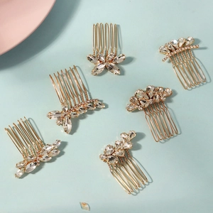 Détail de six peignes de mariée en cristal et feuilles dorées sur un fond bleu clair