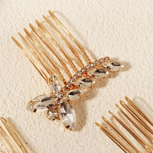 Détail d'un peigne à cheveux de mariée doré avec cristaux marquise sur pierre texturée