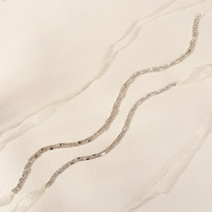 Detail view of luxury bridal double-row rhinestone belt with elegant white silk ribbon