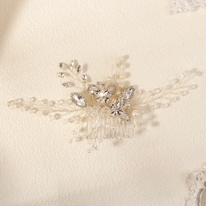 Close-up of bridal hair comb with crystal butterflies and white pearls on silver wire