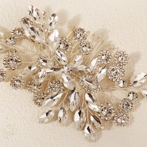 Détail d'un peigne à cheveux de mariée avec fleurs en cristal et fils argentés fins