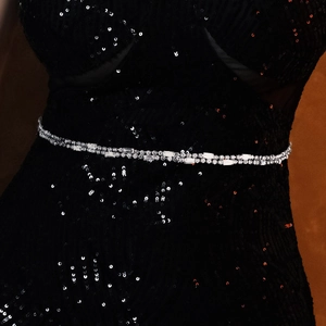 Detail shot of a double-row silver rhinestone bridal waist chain on a black sequin dress