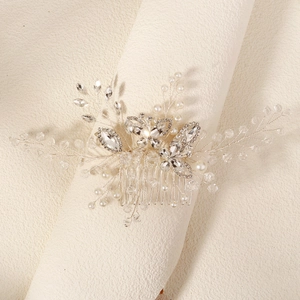 Macro shot of silver bridal hair comb with crystal butterfly and pearl details