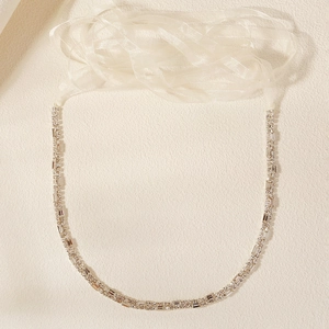 Close-up of luxury bridal double-row rhinestone chain with white organza ribbon ties