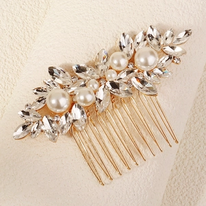 Detail view of luxurious gold bridal hair comb with elegant white pearls and crystals