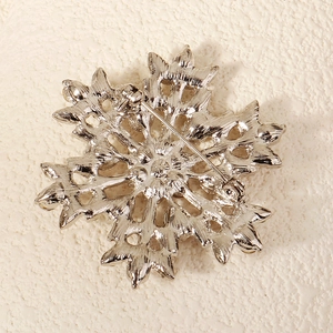 Detail view of the silver snowflake brooch back showing the secure alloy pin fastening