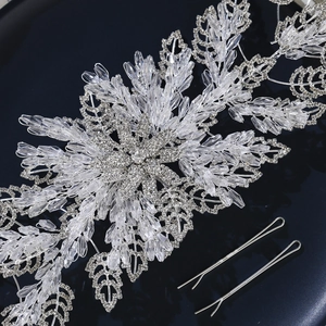 Luxury silver bridal headband with crystal leaves and snowflake design on dark blue backdrop