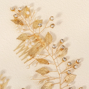 Détail d'un peigne à cheveux de mariée avec feuilles dorées, perles et cristaux