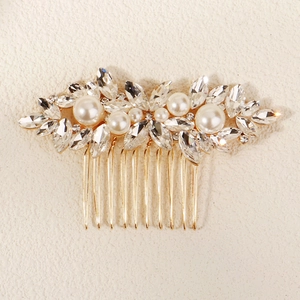 Detail of bridal hair comb with elegant pearls and sparkling rhinestones on gold metal
