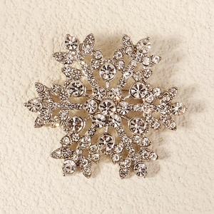 Detailed macro shot of snowflake brooch with silver plating and sparkling rhinestones