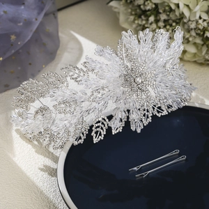 Macro detail of luxury silver crystal bridal headband with rhinestone leaf and hairpin set