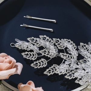 Macro shot of silver bridal hair vine with crystal beads and rhinestones on blue tray
