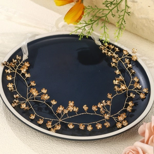Detailed close-up of handmade gold floral bridal hair vine with white organza ribbons