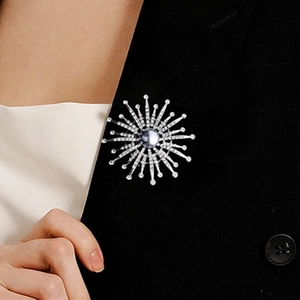 Detailed view of luxury silver snowflake brooch with pearls on a black checkered suit jacket