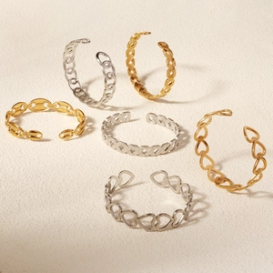 Detail view of gold and silver metallic leaf and heart pattern open cuffs